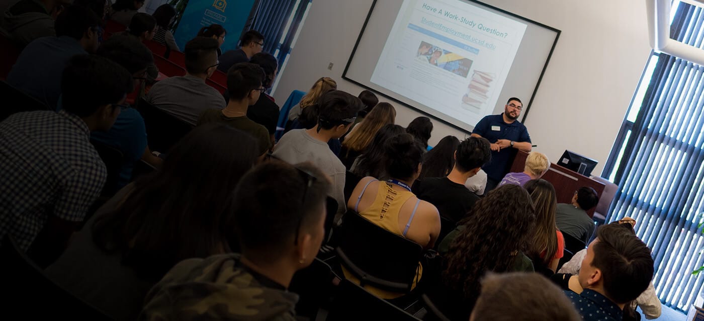 A staff member at a podium giving a lecture to students